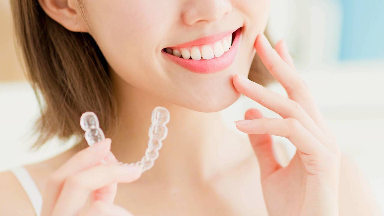 透明のマウスピースを持った女性