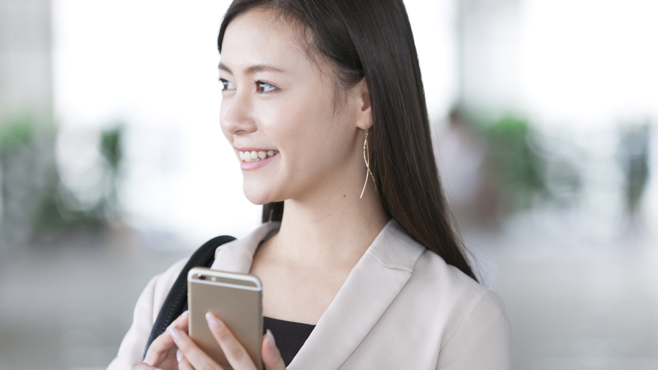 スマートフォンを持った笑顔の女性