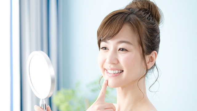 歯並びを確認する笑顔の女性
